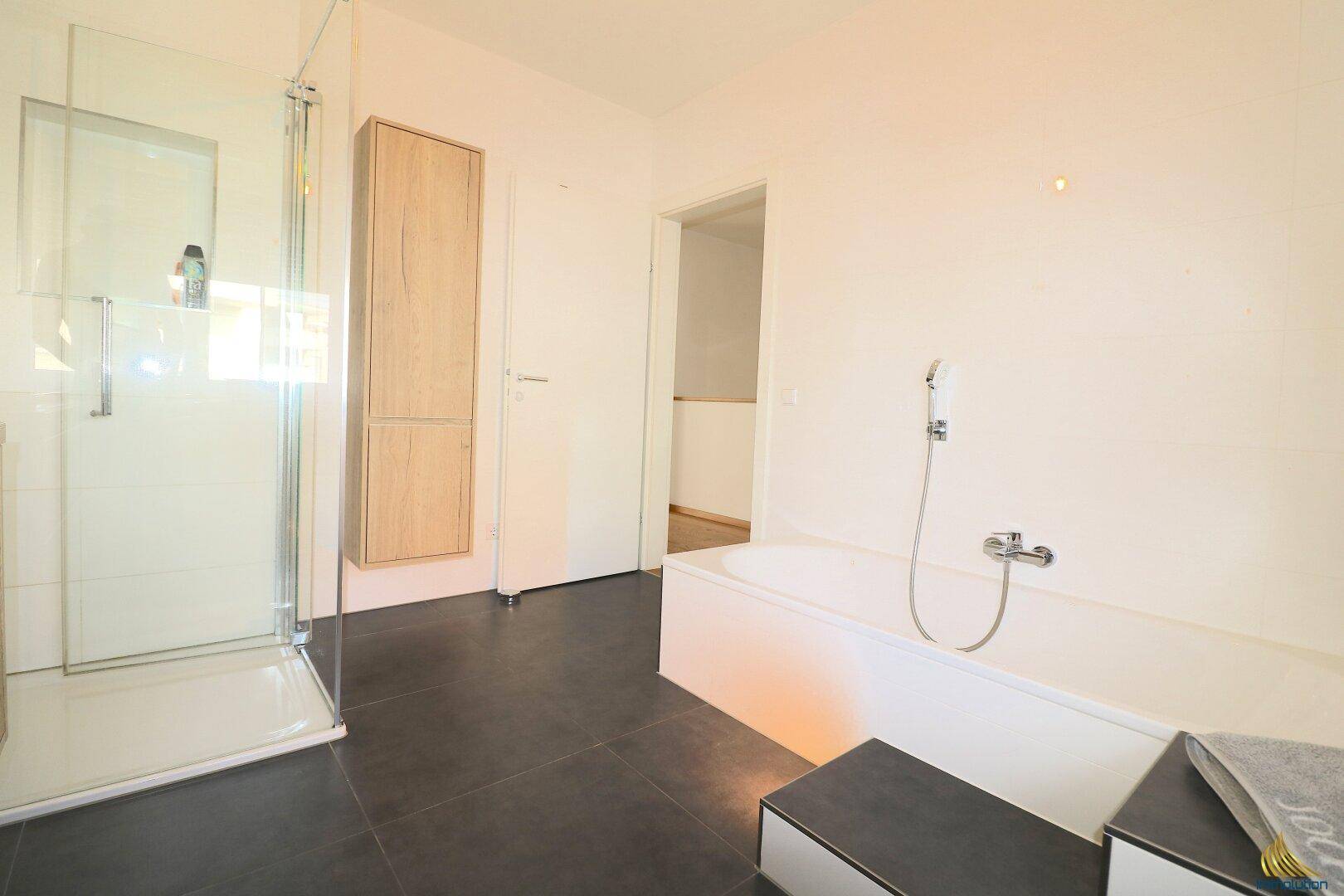Geräumiges Badezimmer mit begehbarer Dusche und integrierter Badewanne.