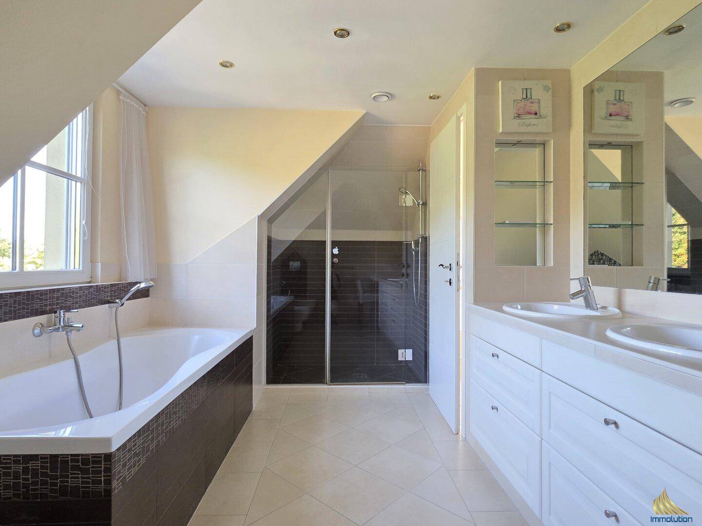 Modernes Badezimmer im Dachgeschoss mit Badewanne, Duschkabine, Doppelwaschbecken und Fenster.