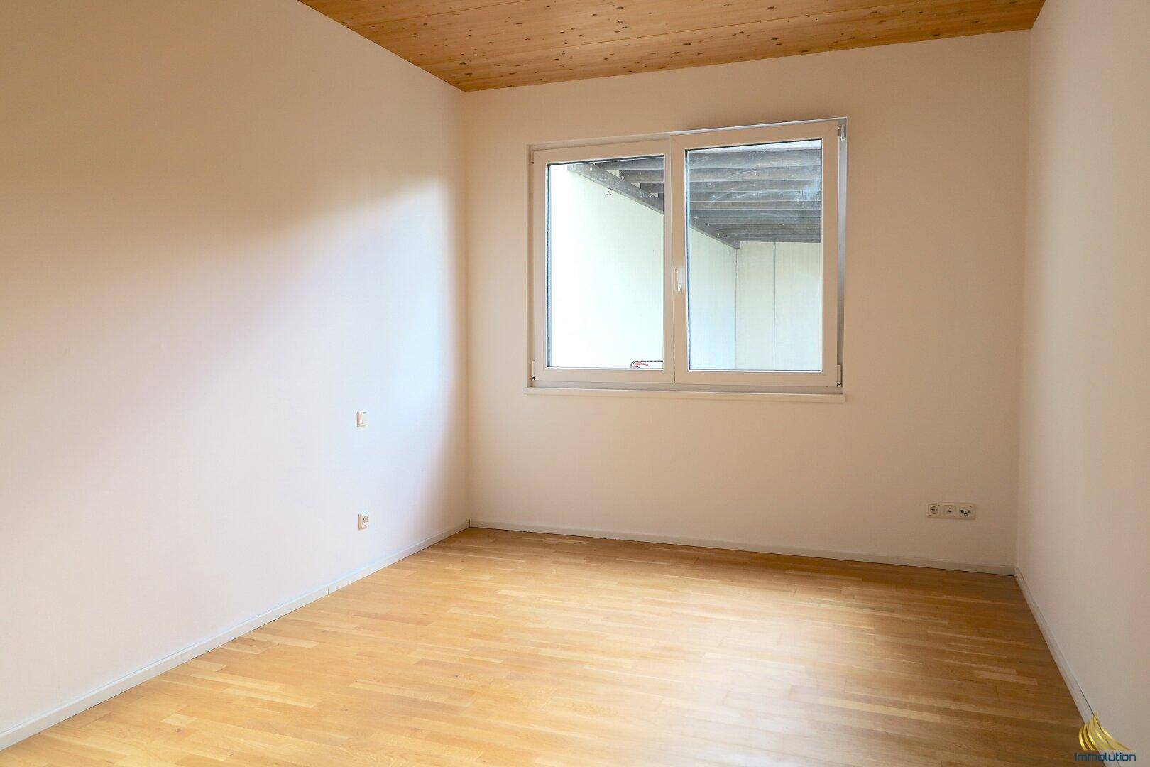 Ruhiges Zimmer mit hellem Holzboden und Holzdecke, ideal als Schlafzimmer oder Kinderzimmer.