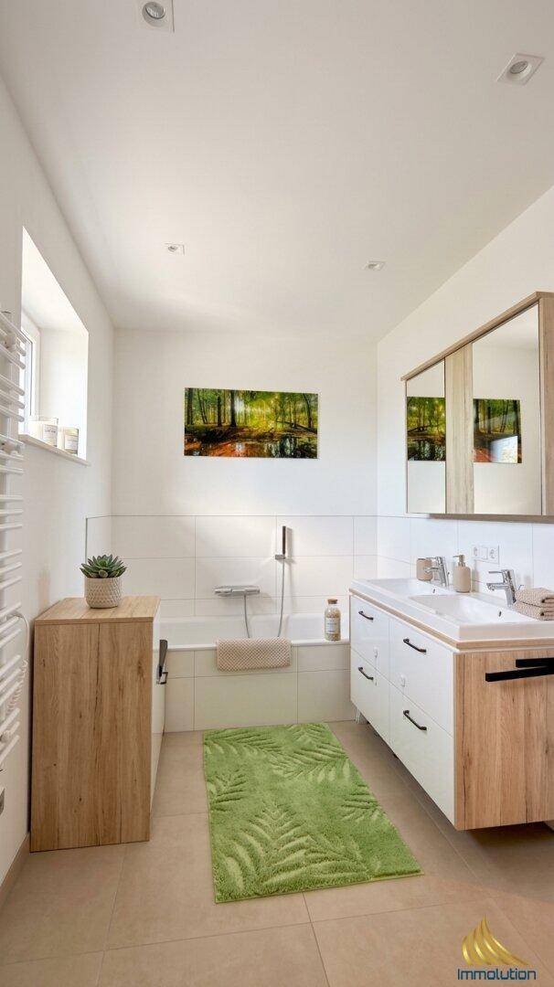 Modernes Badezimmer mit Badewanne, Doppelwaschbecken und Fenster für Tageslicht.