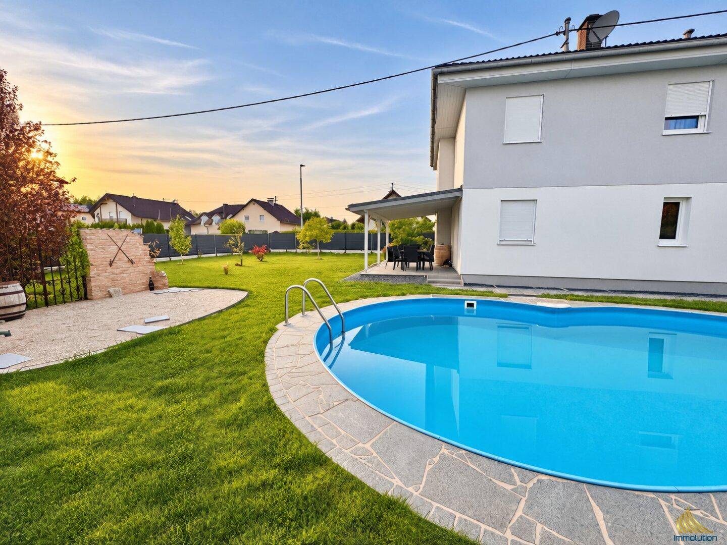 Gepflegter Gartenbereich mit erfrischendem Pool und überdachter Terrasse am Haus.