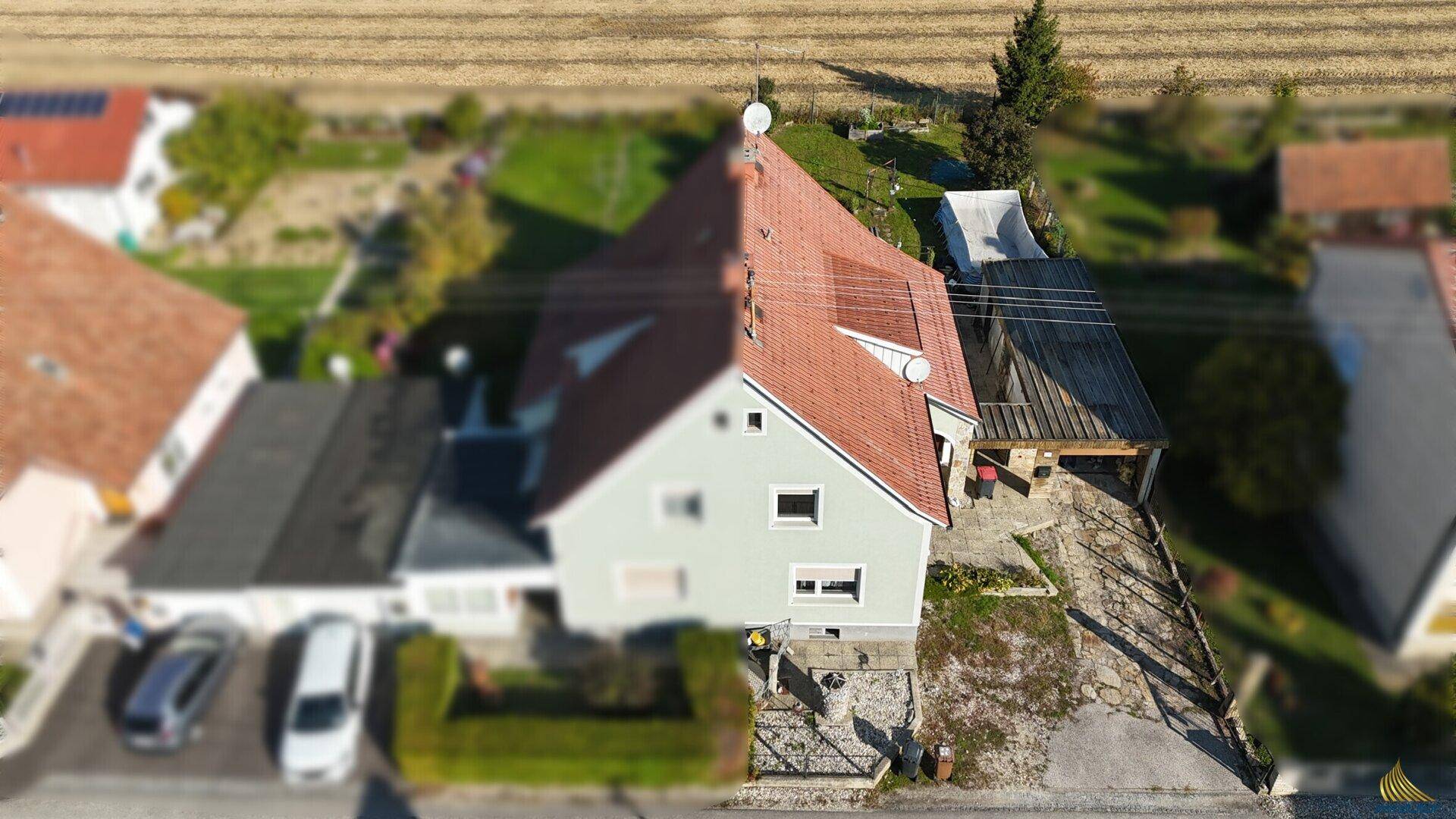 Vogelperspektive des Hauses mit Vorgarten, Carport und weitem Blick über die Felder.