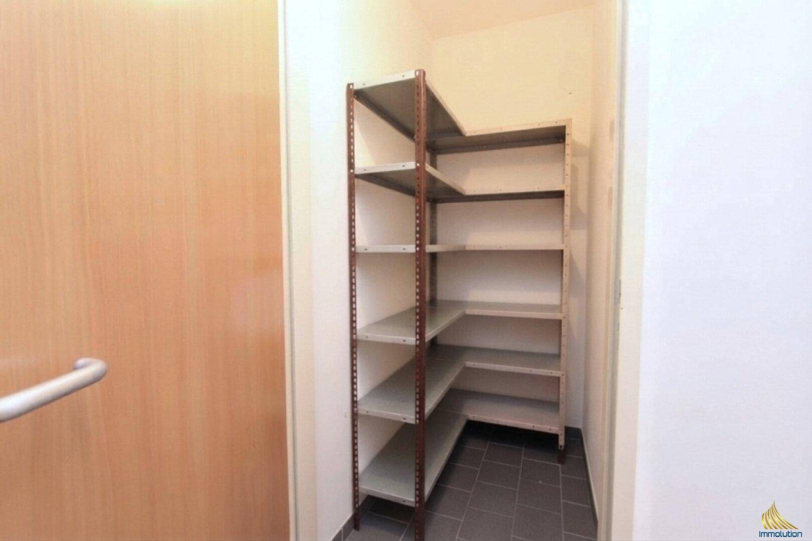 Kleiner Abstellraum mit praktischen Metallregalen für zusätzlichen Stauraum.