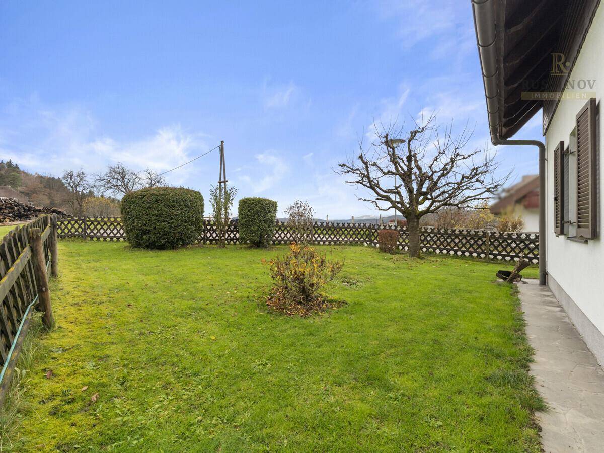 Großer, gepflegter Garten mit Rasenfläche, Hecken und alten Bäumen, ideal für Erholung im Freien.