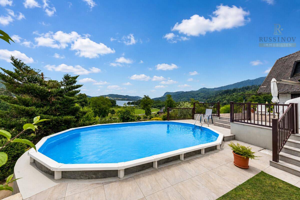 Außenbereich mit Pool und Terrasse, die einen atemberaubenden Blick auf den See bietet.