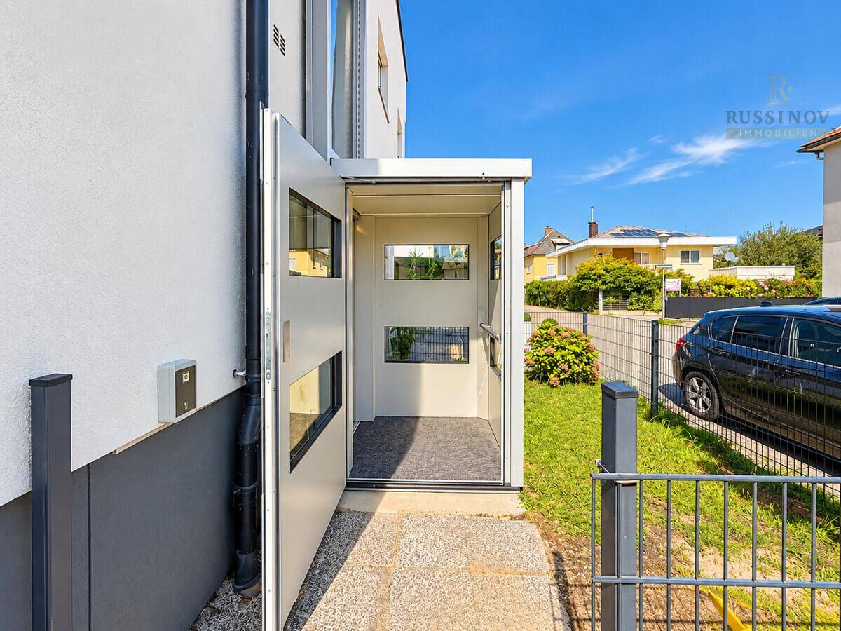 Außenansicht eines Hauses mit einem modernen Aufzug für barrierefreien Zugang zum Eingang.