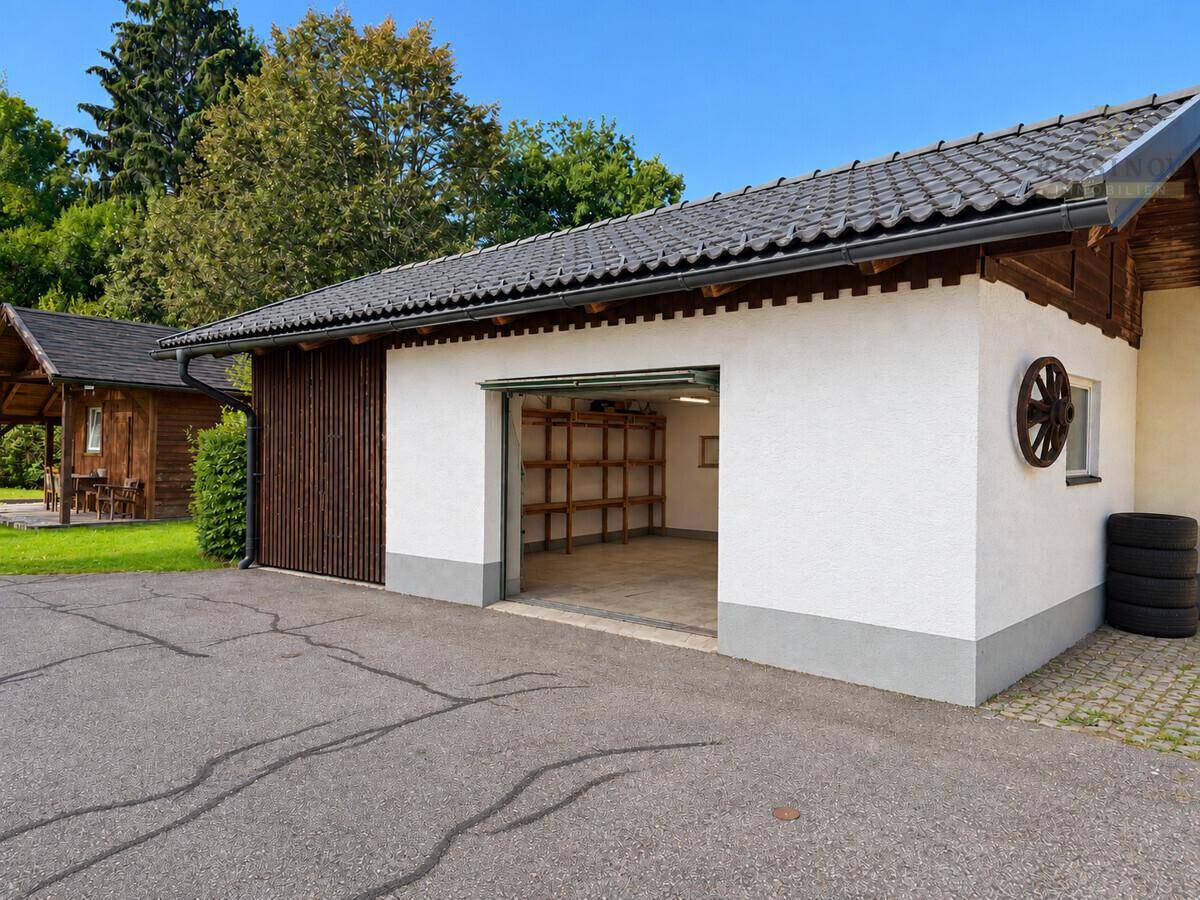 Separate Garage mit offenem Tor und Regalen für Lagerung.