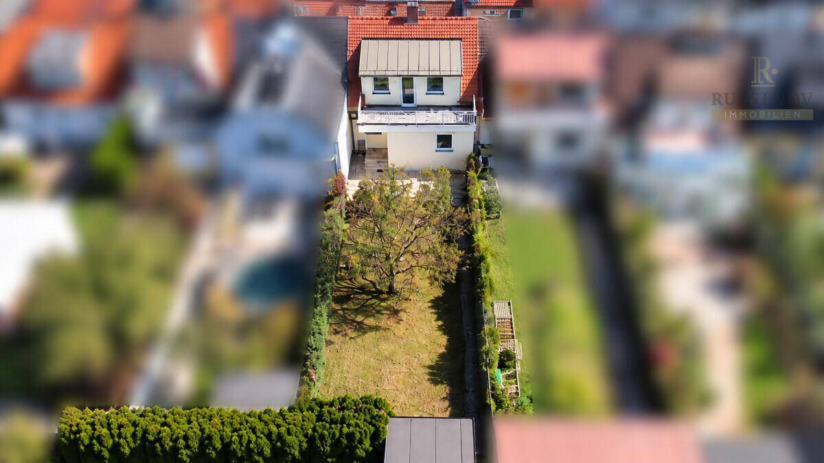Vogelperspektive des Reihenhauses mit langem Garten, Obstbaum und umzäuntem Grundstück.