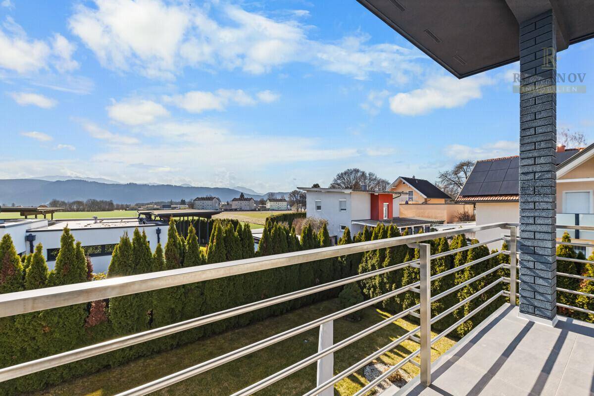 Großer Balkon mit Edelstahlgeländer und weitem Blick über die Landschaft.