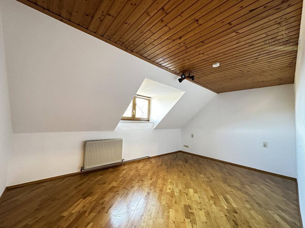 Helles Zimmer mit Holzdecke, Holzboden und Dachschräge, ideal als Schlaf- oder Arbeitszimmer.