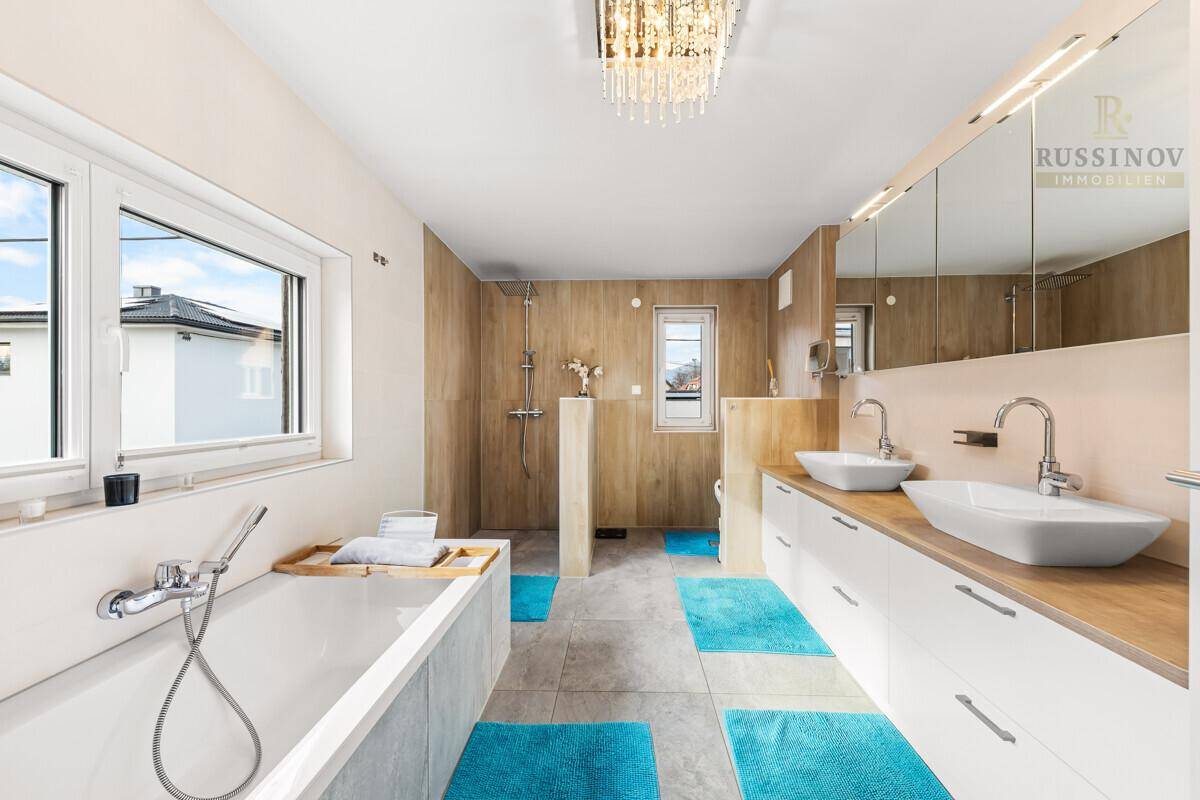 Großes modernes Badezimmer mit Badewanne, Doppelwaschbecken und separatem Duschbereich.