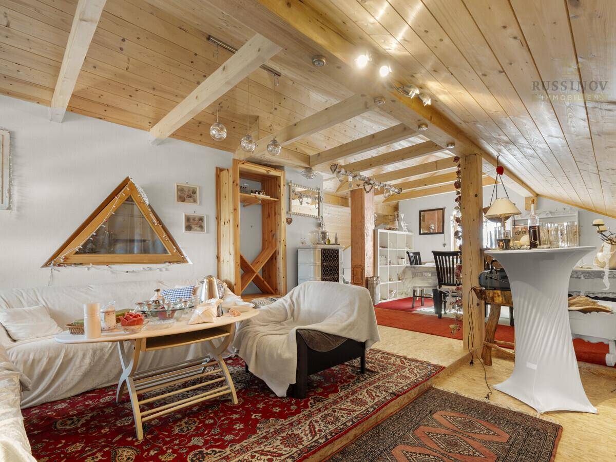 Heller Dachbodenraum mit Holzbalken, schrägen Wänden und rustikalem Charme.