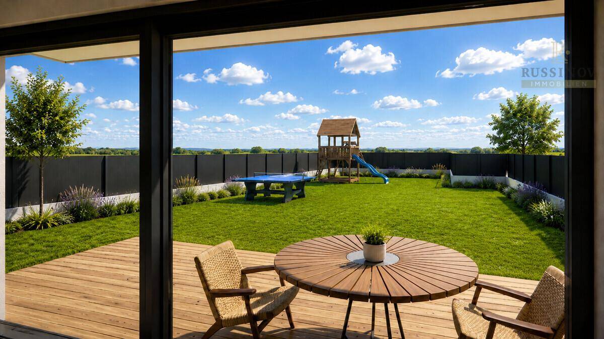 Blick von der Holzterrasse in den weitläufigen Garten mit Spielplatz und Tischtennisplatte.