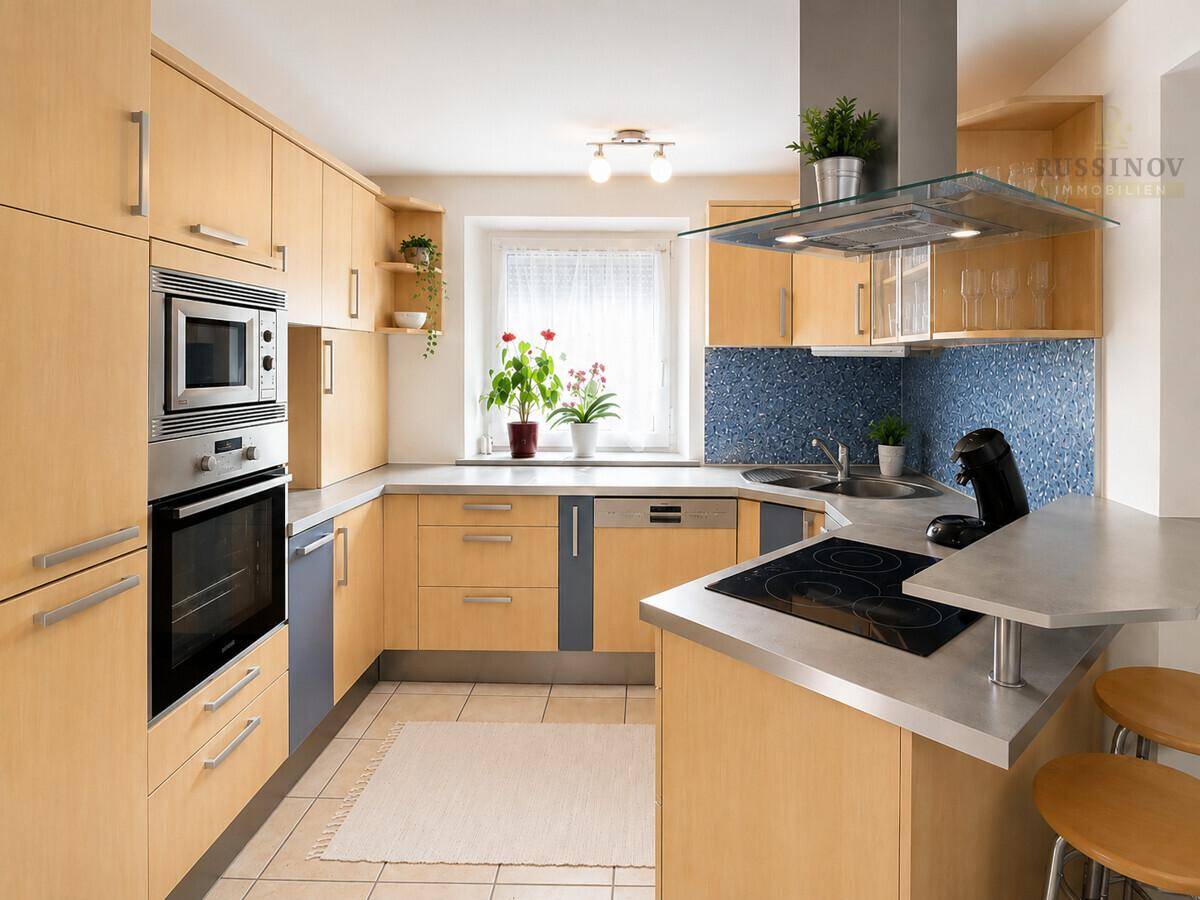 Moderne Küche mit hellen Holzfronten, blauer Fliesenrückwand und integrierten Geräten.