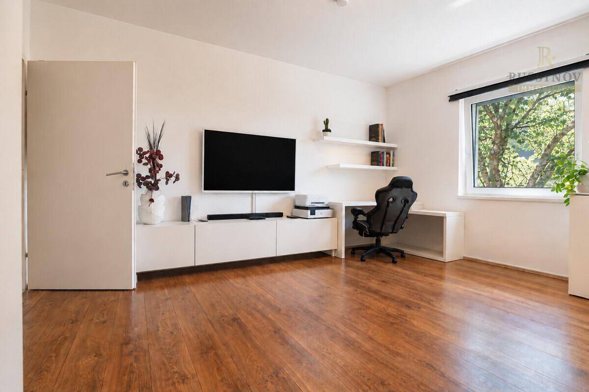 Helles Zimmer mit Holzboden, als Büro oder Medienraum nutzbar, mit großem Fenster.