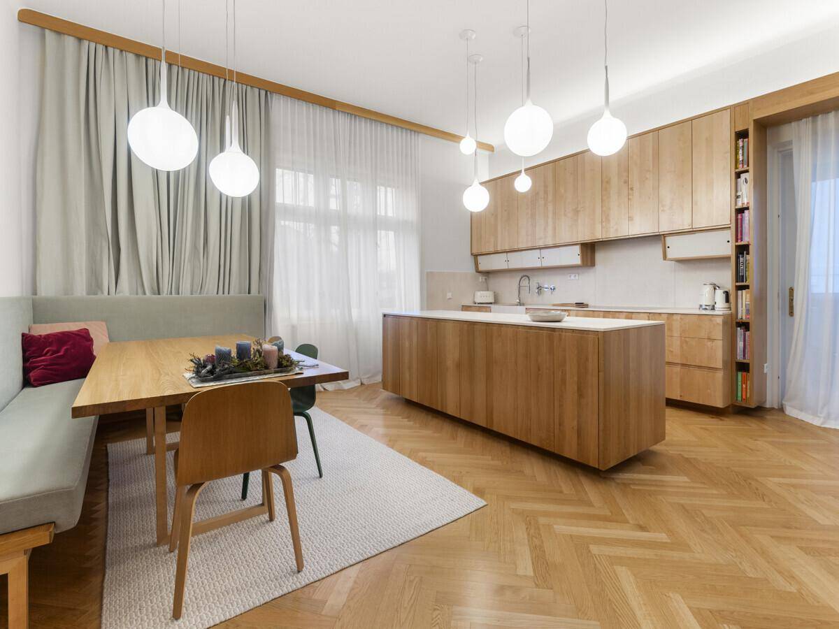 Moderne Holzküche mit Kücheninsel, integriertem Essbereich und Fischgrätparkettboden.