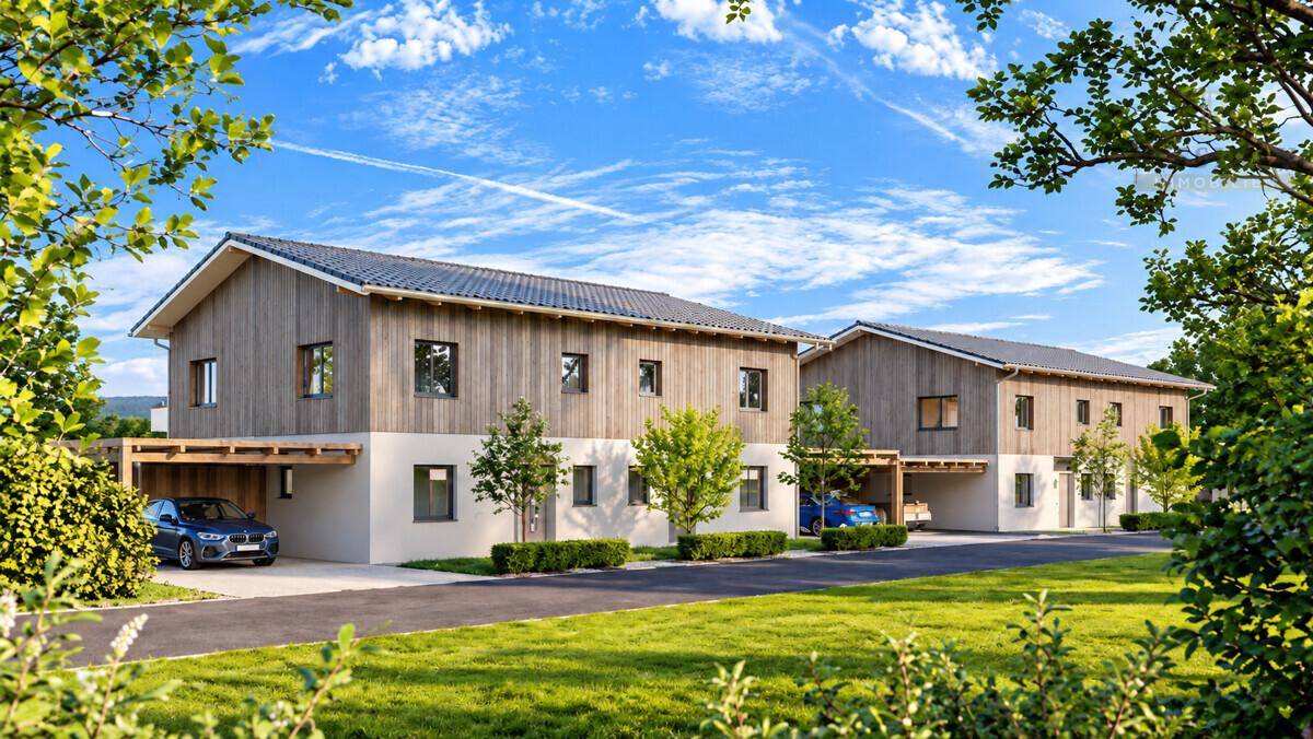 Ansicht der modernen Doppelhäuser mit Carports und gepflegten Grünflächen unter blauem Himmel.
