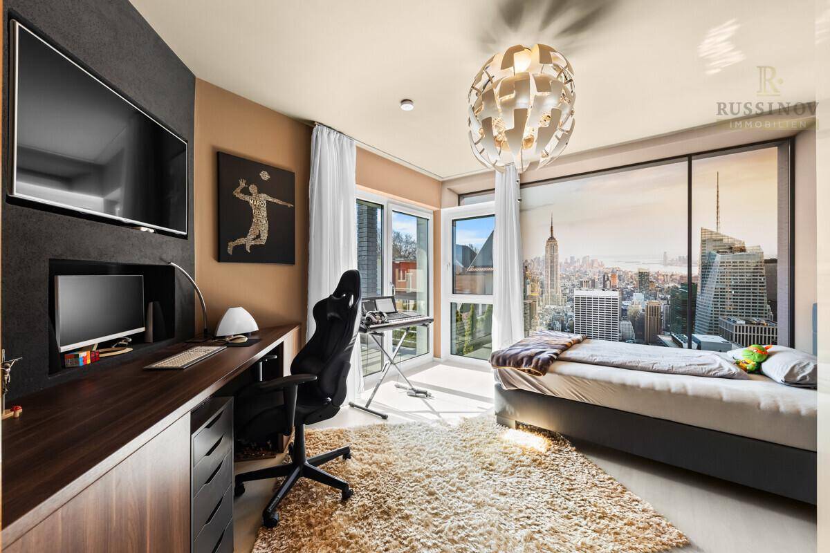 Modernes Schlafzimmer mit großem Fenster, Schreibtisch und moderner Einrichtung.