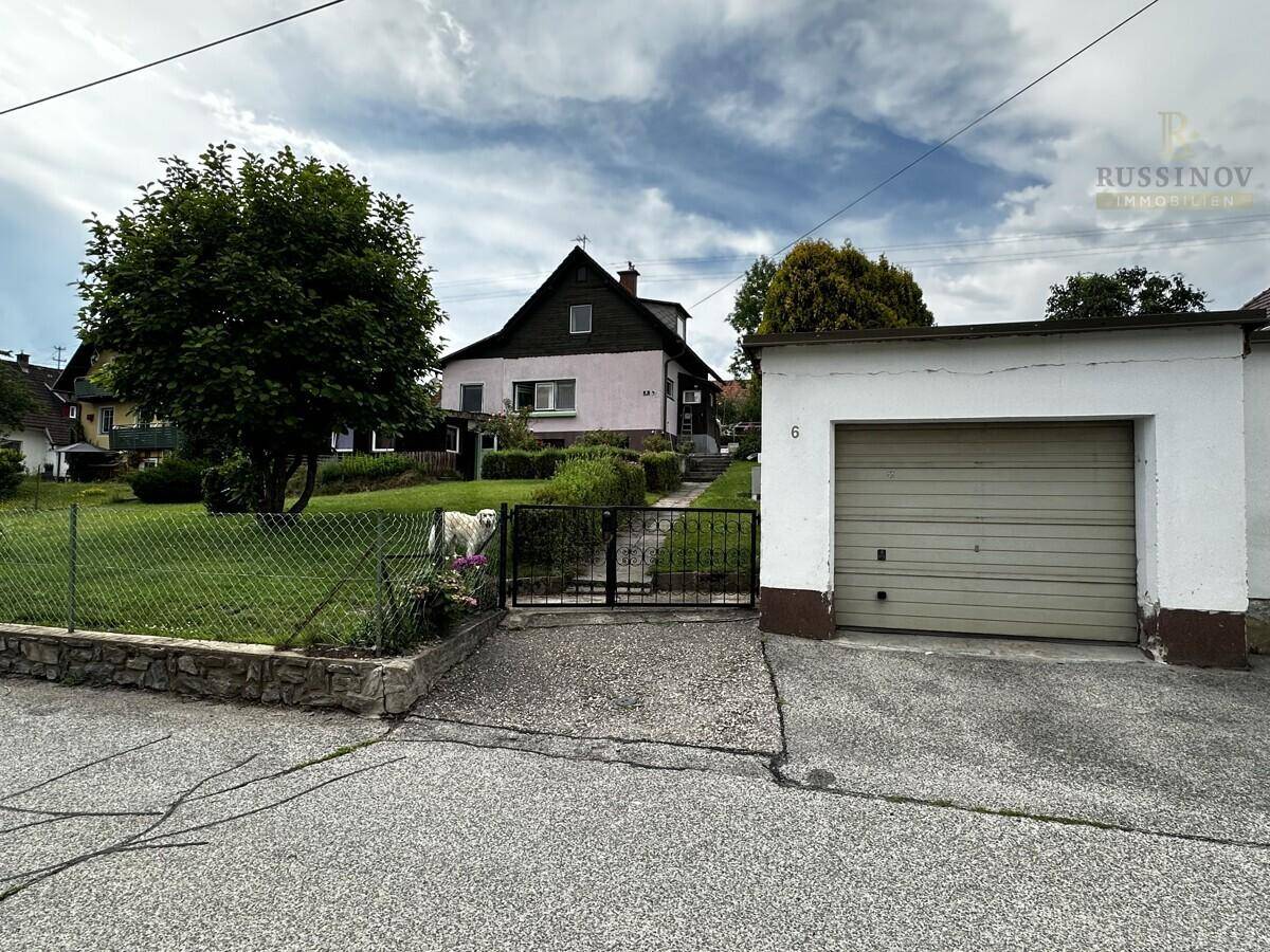 Einfahrt zum Grundstück mit einer freistehenden Garage und Blick auf das Wohnhaus.