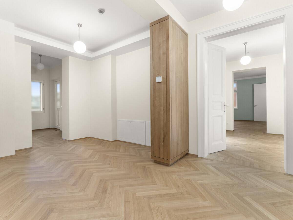 Heller, leerer Raum mit Fischgrätparkett und hohen Decken, bereit zur individuellen Gestaltung.