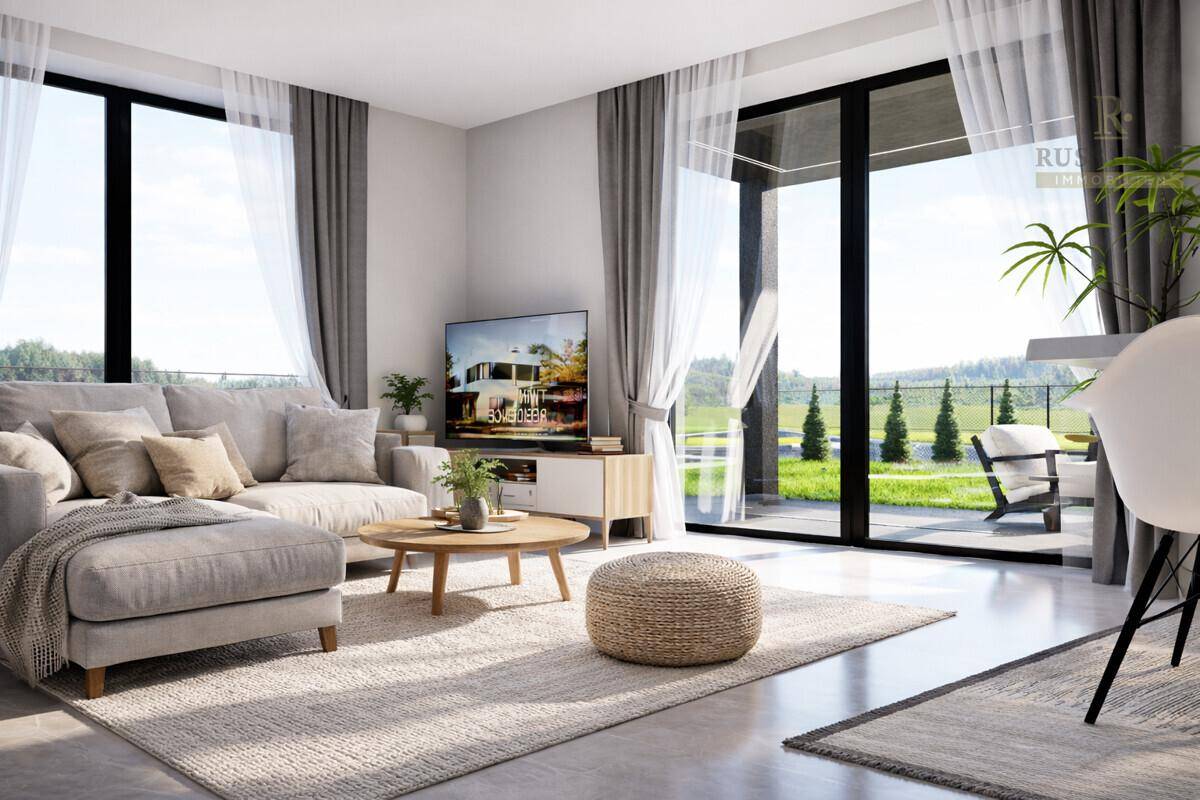 Helles Wohnzimmer mit großen Fenstern, modernem Sofa und Blick ins Grüne.