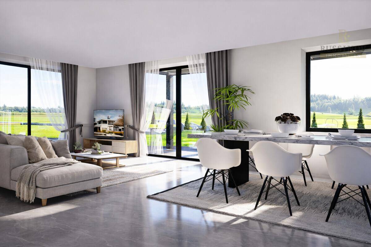 Offener Wohn- und Essbereich mit modernem Design, großen Fenstern und Zugang zur Terrasse.