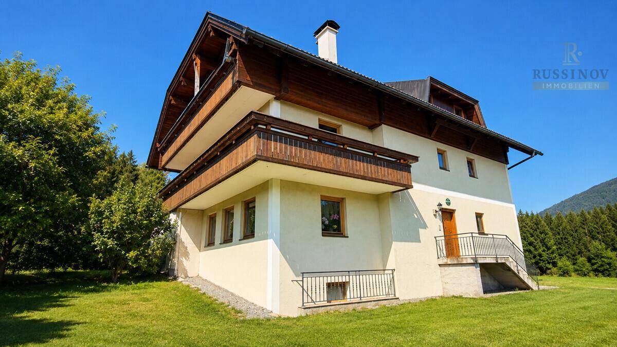 Seitenansicht des Hauses mit Außentreppe zum Eingang und weitem Blick ins Grüne.