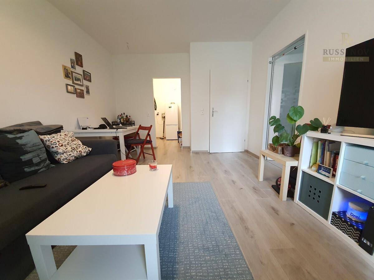 Offener Wohnbereich mit Essplatz, Sofa und Blick in den Flur.