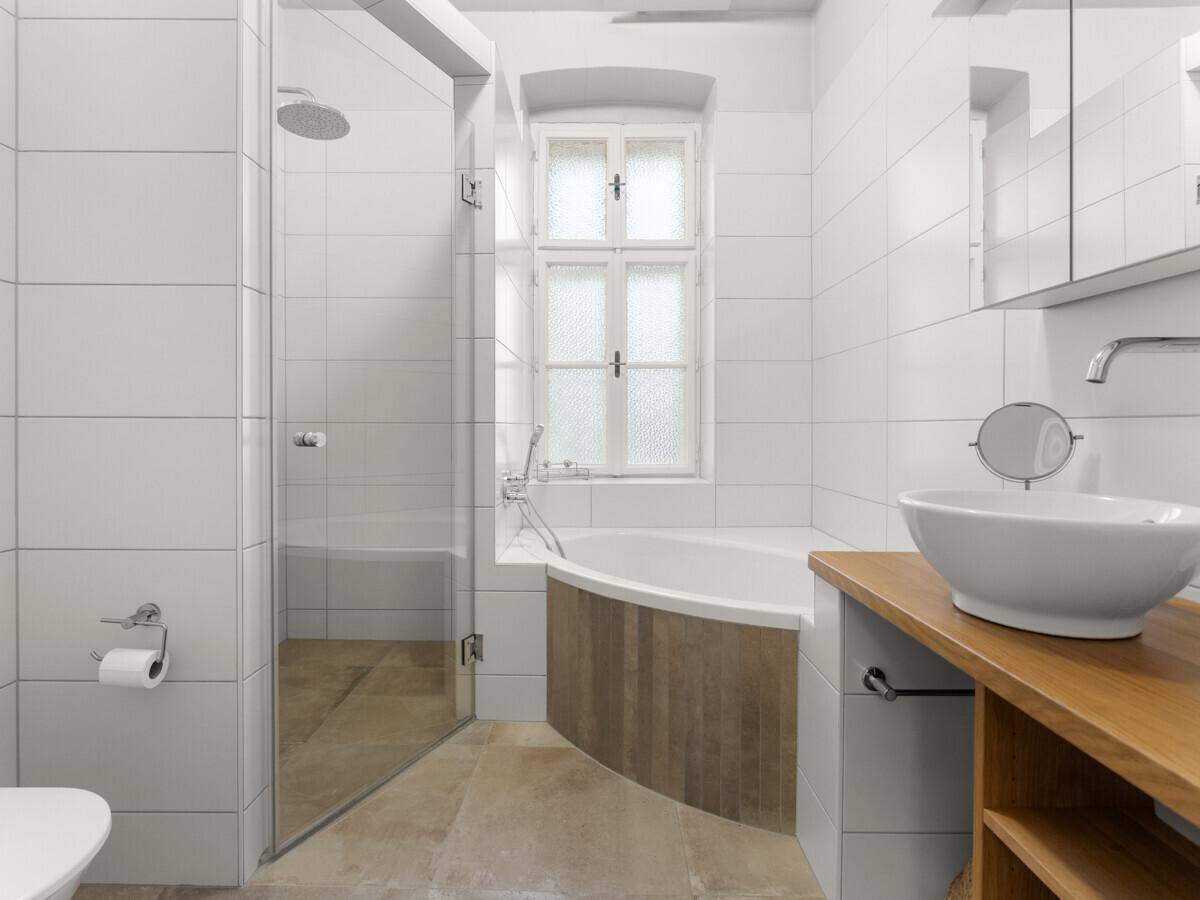 Modernes Badezimmer mit begehbarer Dusche, Eckbadewanne und Fenster für Tageslicht.