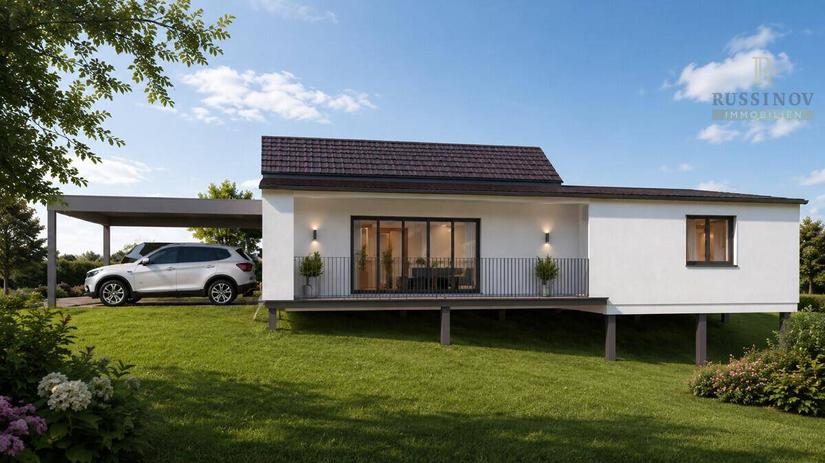 Modernes Haus mit Satteldach, erhöhtem Balkon und Carport in ländlicher Umgebung.