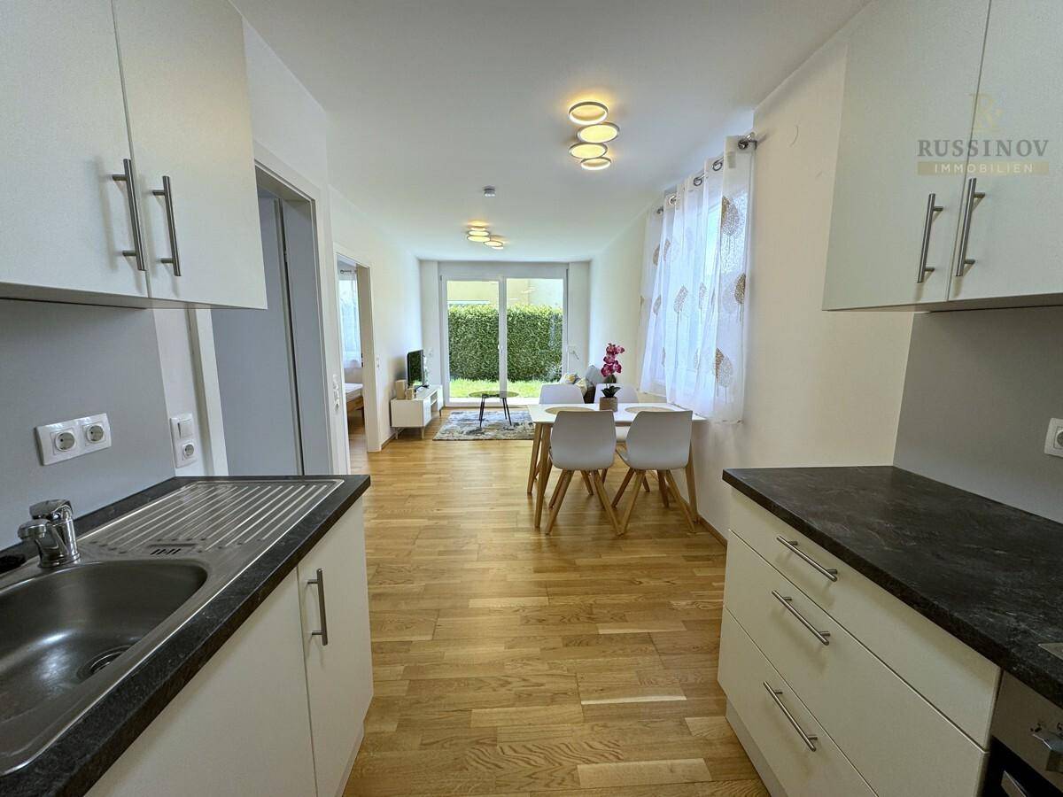 Offener Wohn- und Essbereich mit integrierter Küche und direktem Zugang zum Garten.