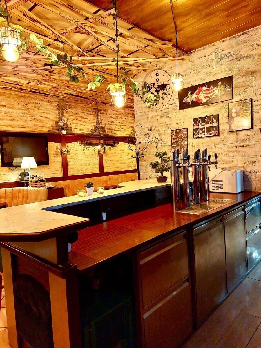 Bar- und Restaurantbereich mit Holztresen, Zapfanlage und dekorativer Ziegelwand.