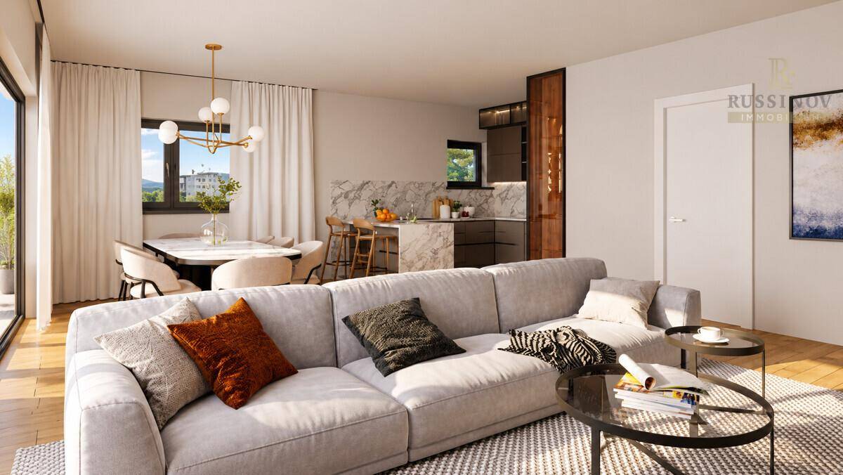 Offener Wohn-Essbereich mit moderner Küche, bequemer Couch und Zugang zum Balkon.