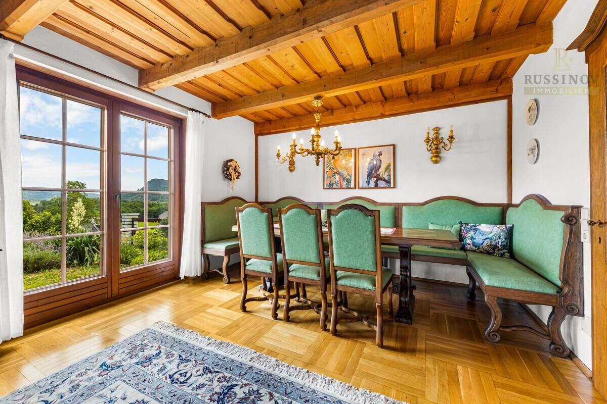 Traditioneller Essbereich mit Holzbalkendecke, Parkettboden und eingebauten Sitzbänken.