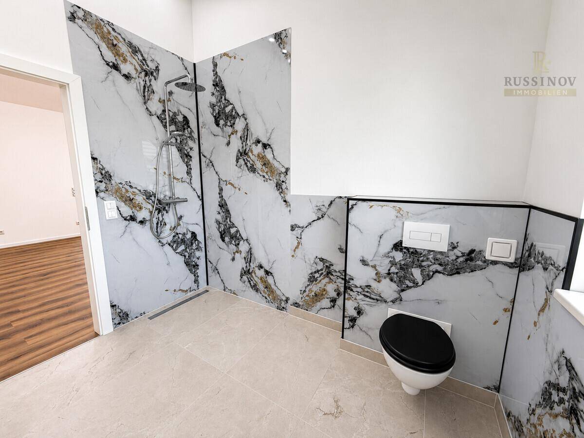 Modernes Badezimmer mit eleganten Marmorfliesen, ebenerdiger Dusche und Wand-WC.