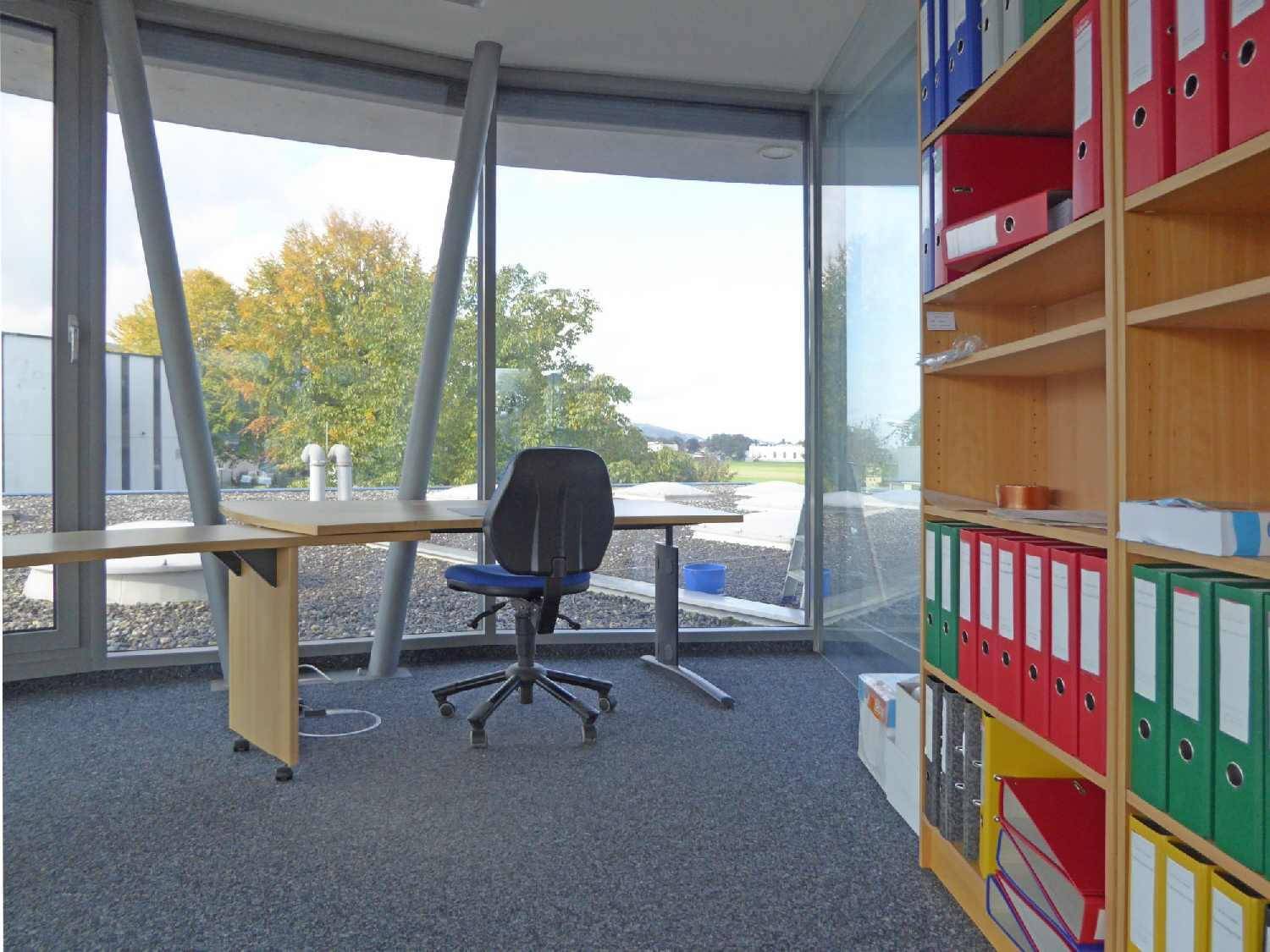 Geräumiger Bürobereich mit Schreibtisch, Bürostuhl und Panoramablick auf die umliegende Landschaft.