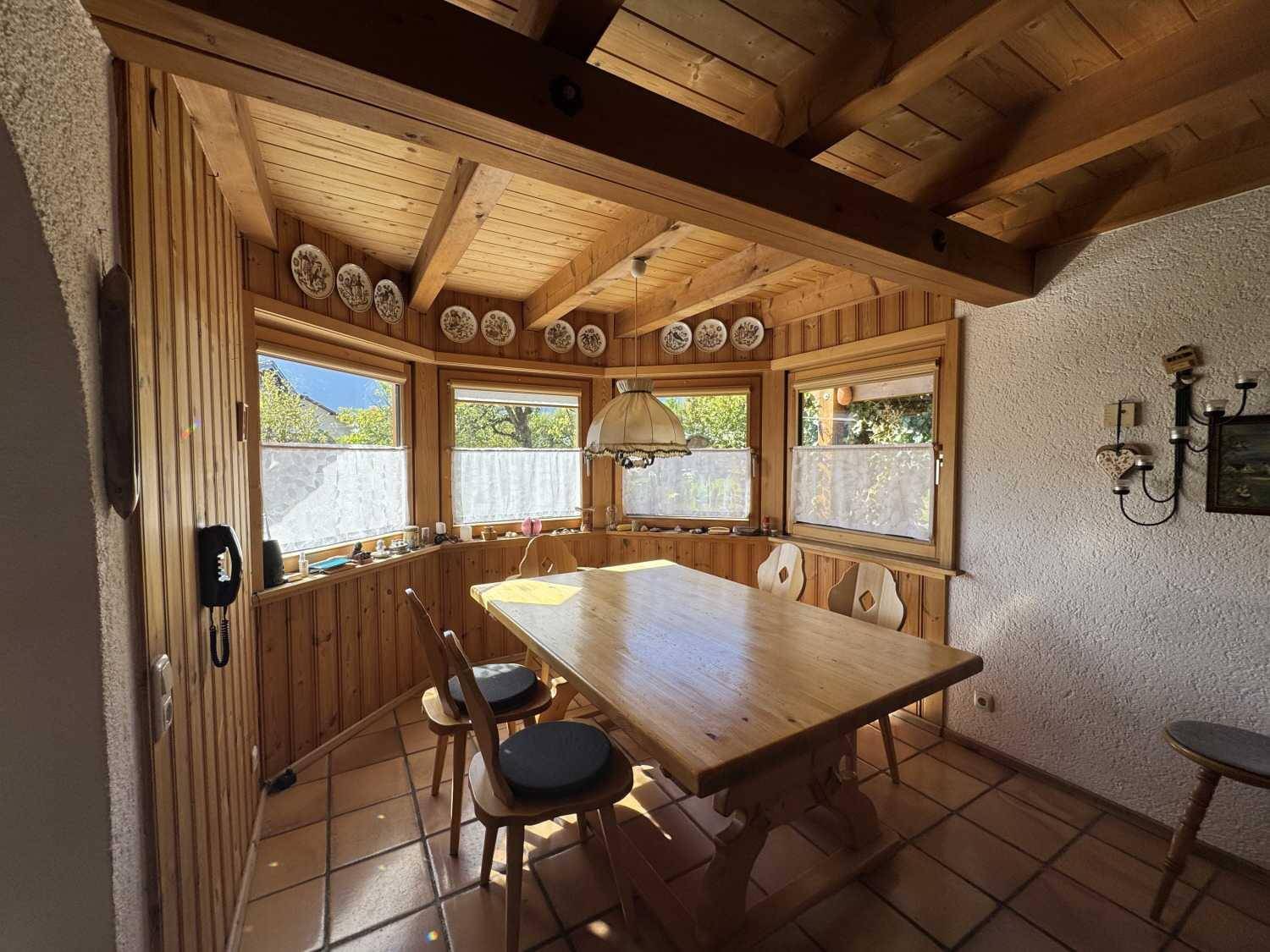 Gemütlicher Essbereich mit Holzvertäfelung, Holzbalkendecke und Terrakottafliesen.
