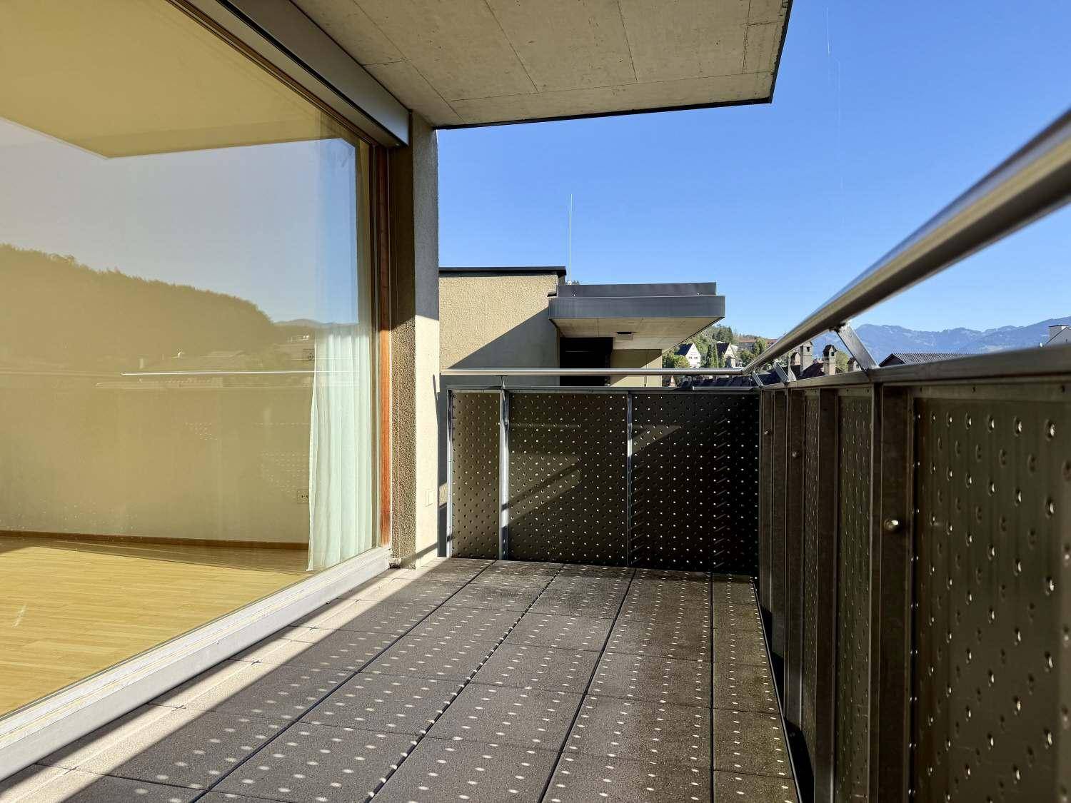Heller Balkon mit Fliesenboden und Metallgeländer, bietet einen schönen Blick auf die Berge.