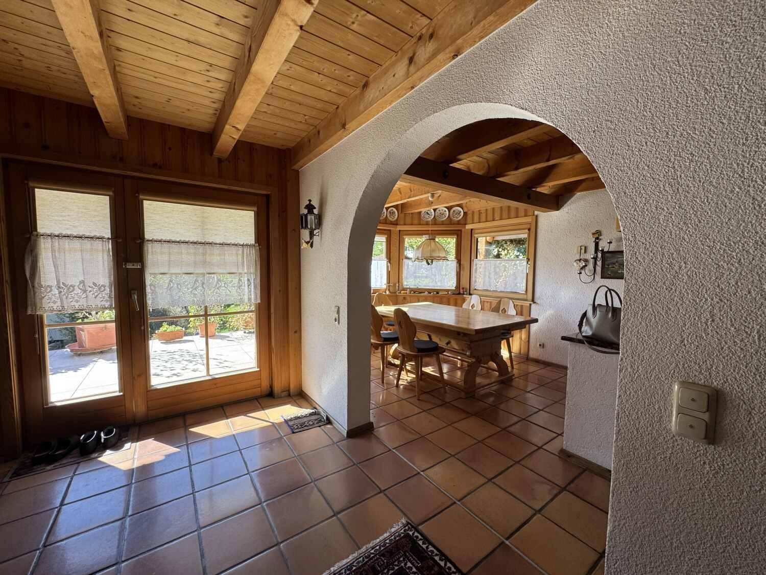 Heller Durchgang zum Essbereich mit Terrakottafliesen und Zugang zur Terrasse.
