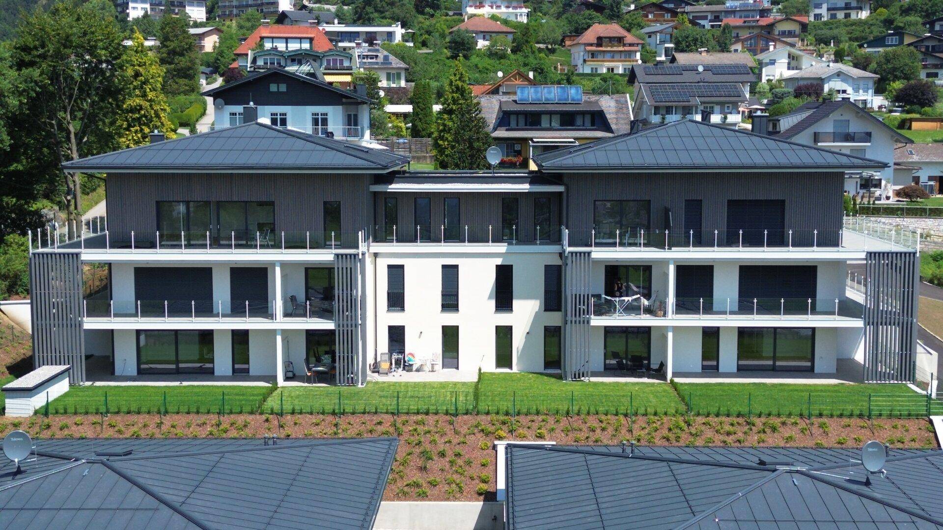 Detailansicht der modernen Fassade des Hauptgebäudes mit großen Balkonen und Glasgeländern.
