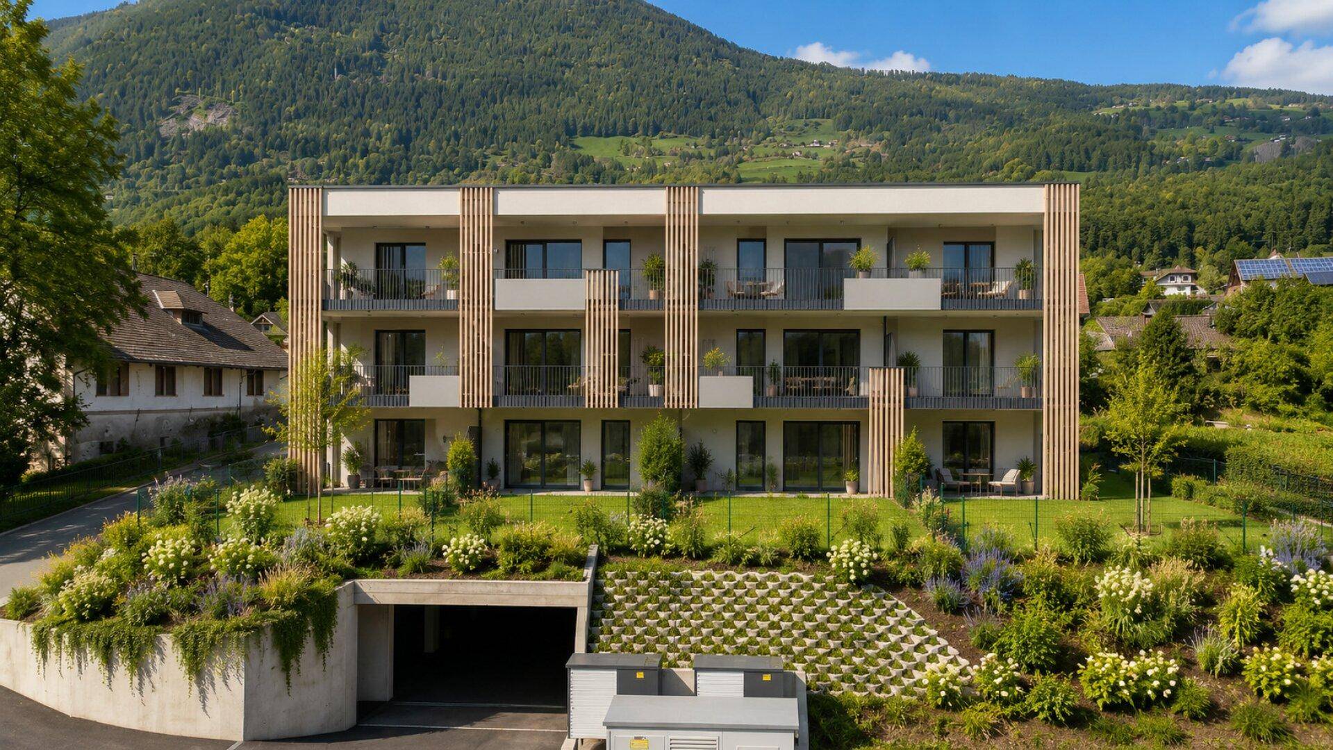 Weitläufige Ansicht der modernen Wohnanlage mit Balkonen, Terrassen und Tiefgaragenzugang.