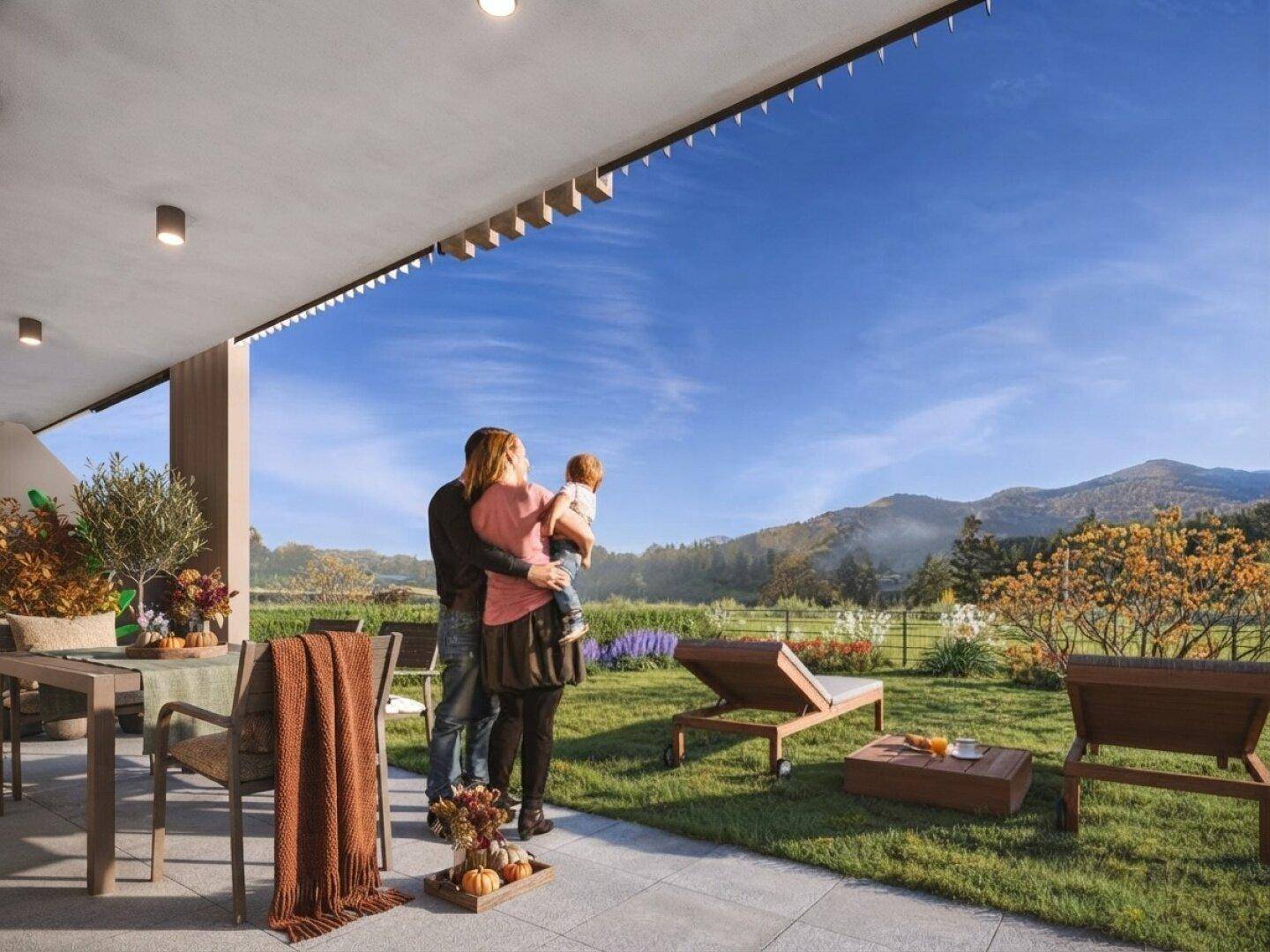 Große, überdachte Terrasse mit Gartenmöbeln und weitem Blick auf die umliegende Berglandschaft.