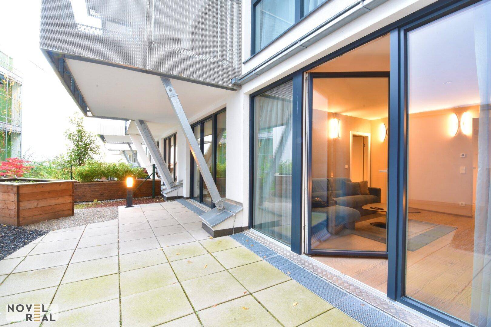 Geräumige Terrasse mit Fliesenboden und Zugang zu den Innenräumen, ideal für Entspannung im Freien.