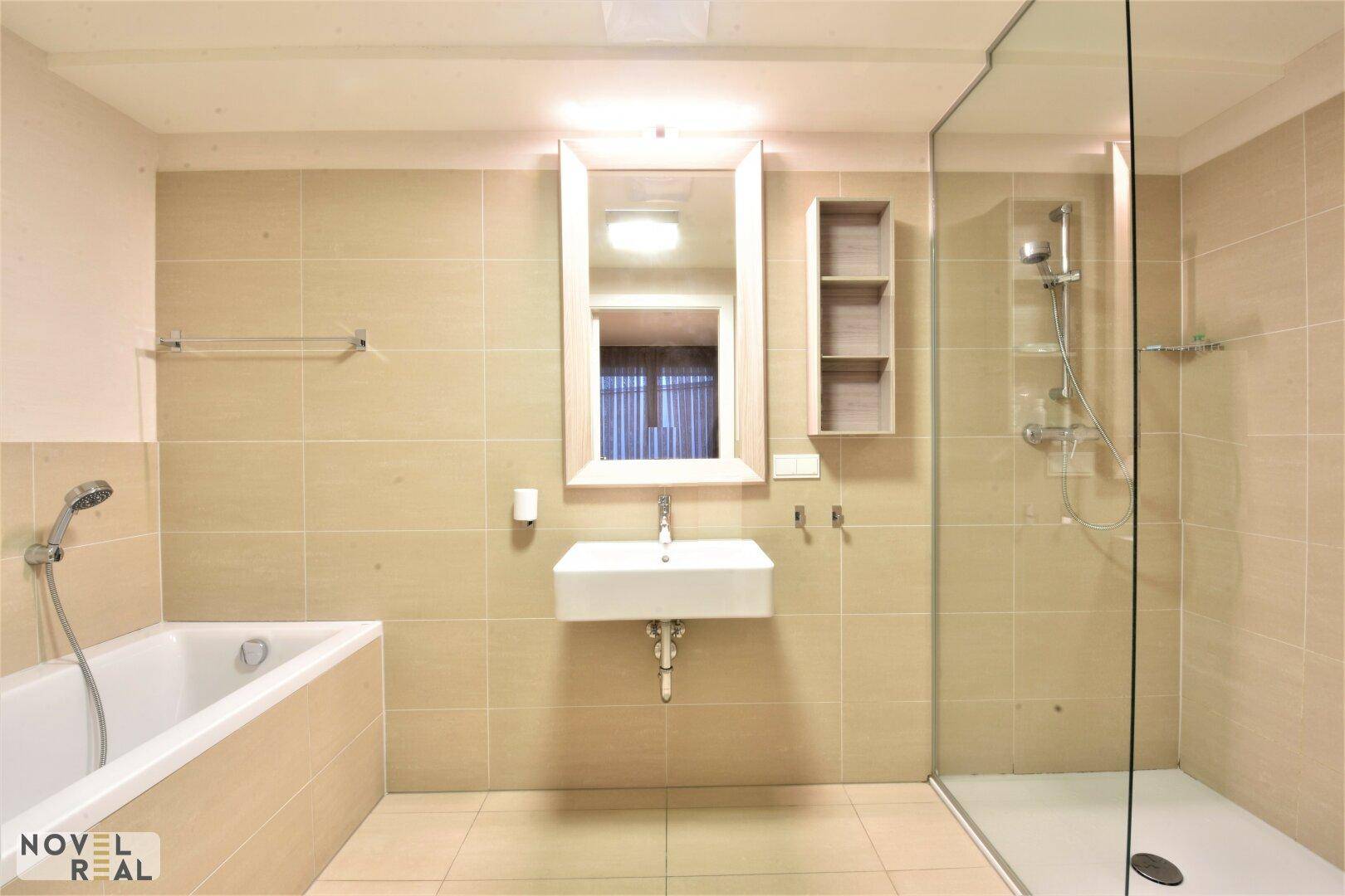 Modernes Badezimmer mit Badewanne, Duschkabine und großem Spiegel über dem Waschbecken.