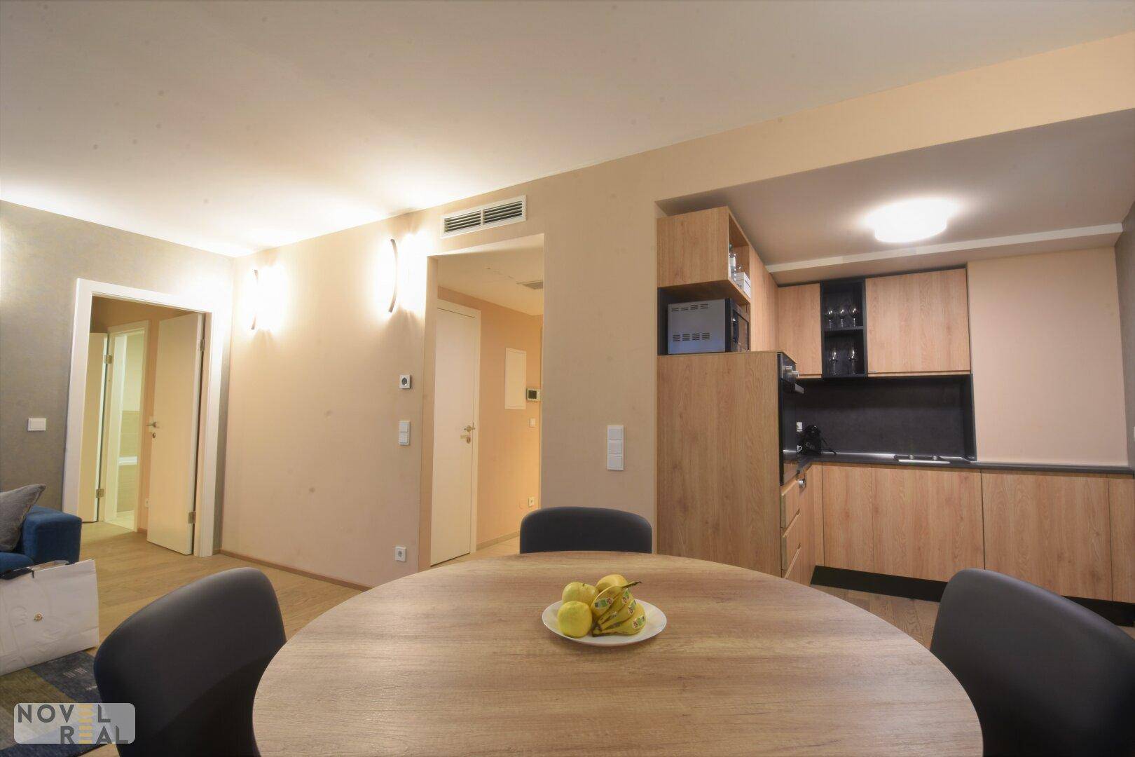Offener Wohnbereich mit Esstisch und integrierter Küchenzeile in modernem Design.