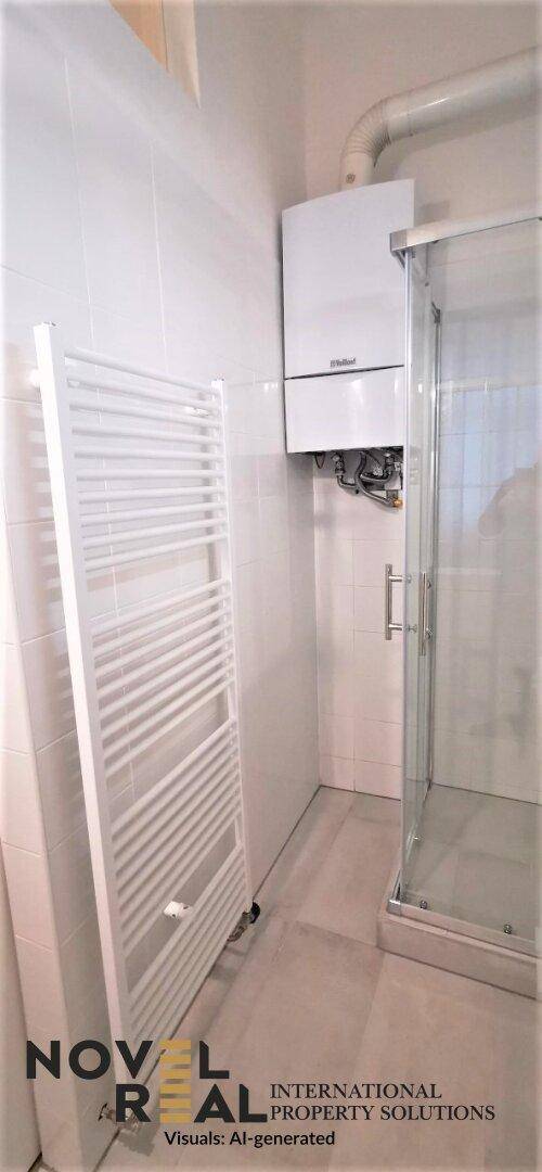 Badezimmer mit Duschkabine, Handtuchheizkörper und Warmwasserbereiter an der Wand.