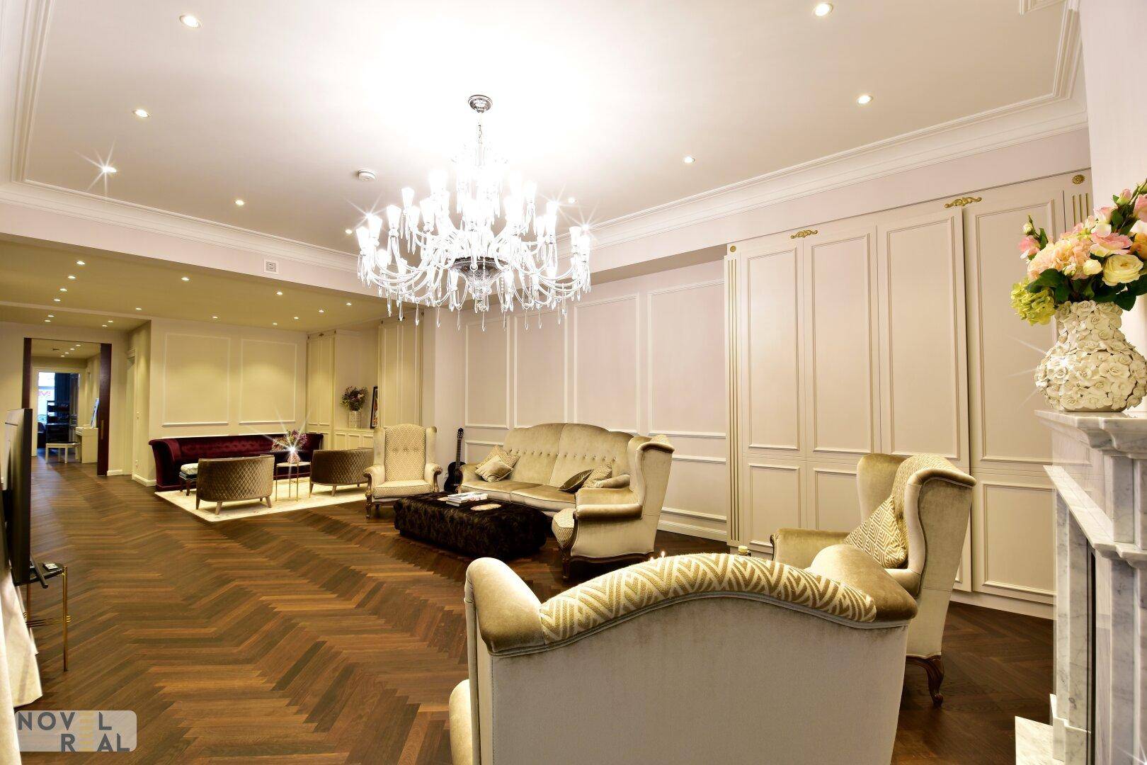Geräumiges Wohnzimmer mit klassischem Mobiliar, Wandvertäfelungen und luxuriösem Ambiente.
