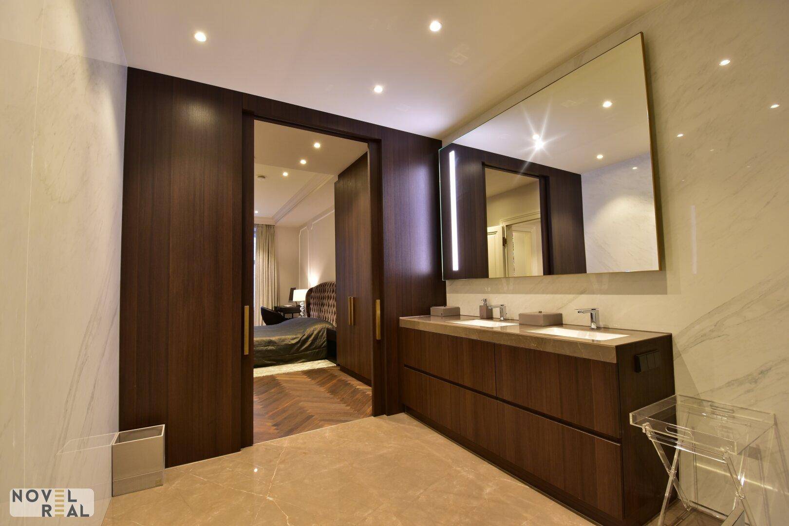 Elegantes Badezimmer mit Doppelwaschbecken und direktem Zugang zum Schlafzimmer.