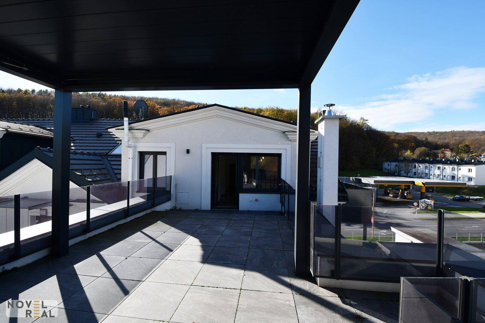 Geräumige Dachterrasse mit Blick auf die Umgebung und Zugang zum Gebäude.