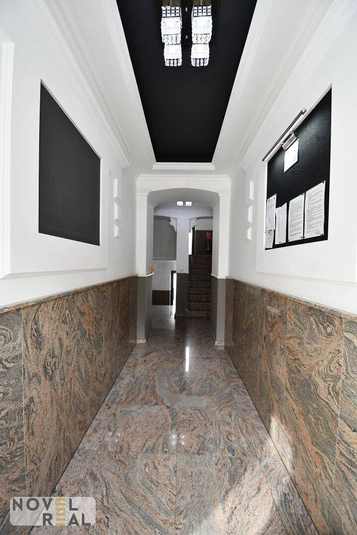 Repräsentativer Eingangsbereich mit Marmorboden und dunkler Decke.